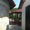 Un patio con tavolino sotto un gazebo in legno.