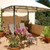 Due sdraio sotto un gazebo con piante fiorite in vaso su una terrazza.