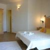 Una camera da letto con letto matrimoniale e armadio, pareti bianche e luci calde.