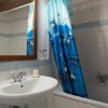 Lavabo accanto ad una vasca con tenda blu.