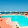 Piscina con vista mare e ombrelloni bianchi.