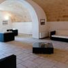 Stanza con soffitto ad arco, arredi moderni e pavimento in pietra chiara.