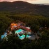 Veduta notturna di un resort con piscine illuminate.