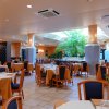 Ristorante elegante con tavoli apparecchiati e piante decorative.