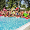Persone festose attorno a una piscina con gonfiabili.