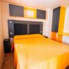 Camera da letto con letto matrimoniale e arredi arancioni.