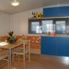 Cucina e zona pranzo con mobili blu.