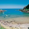 Baia tranquilla con acqua turchese e scogli.