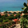 Scalinata con ringhiera che scende verso il mare, cactus ai lati.