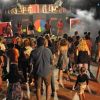 Persone ballano e si divertono di fronte a un palco con luci soffuse.
