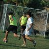Due persone giocano a calcio vicino a una rete.