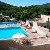 Piscina all'aperto con lettini, circondata da vegetazione.