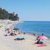Spiaggia affollata con ombrelloni colorati e mare.