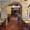 Ristorante con archi in pietra e tavoli apparecchiati.