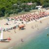 Spiaggia affollata con ombrelloni arancioni.