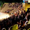 Spettatori seduti in un anfiteatro all'aperto.
