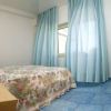 Una camera con letto matrimoniale, tende azzurre e pavimento blu.
