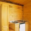 Cucina in legno con lavello, fornelli e un piccolo frigorifero.