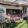 Bar sulla spiaggia con tavoli e sedia in plastica.