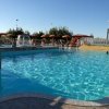 Piscina con ombrelloni arancioni e fontana.