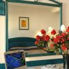 Scrivania con laptop, specchio e fiori.
