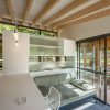 Interno moderno con bancone, divano, tavolo e finestrone.