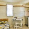 Interno di una casetta con letto, tavolo, e cucina.