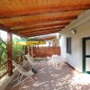 Terrazza coperta con sedie a sdraio e tavolo.