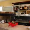 Dettaglio del bancone bar con macchina da caffè e scaffale di liquori.