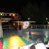 Persone si esibiscono su un palco illuminato di notte.