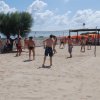 Partita di beach volley sulla sabbia con spettatori.