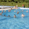 Gruppo di persone nuota in una piscina all'aperto.