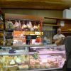 Negozio di alimentari con formaggi e salumi esposti.