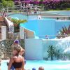 Persone che si rilassano e giocano in un parco acquatico con cascate e scivoli.