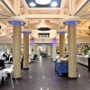 Interno di un ristorante elegante con colonne dorate e tavoli apparecchiati.