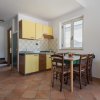 Cucina con mobili gialli e tavolo da pranzo in un interno semplice.