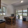 Cucina e salotto con tavolo, divano e uscita sul patio.