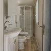 Un bagno con doccia, lavabo, WC e pavimento in legno.