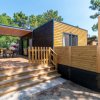 Casa mobile moderna con terrazza e recinzione in legno.