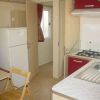 Cucina di un bungalow con fornelli, frigorifero e lavandino, arredamento semplice.