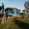 Amaca tra casette blu su prato verde.