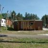 Casa mobile marrone con veranda, vicina a una roulotte.