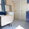Interno di una casa mobile con tavolo pieghevole, divano blu e angolo cottura blu.