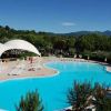 Una piscina con sedie a sdraio e grandi tendoni bianchi.