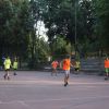 Partita di calcio con ragazzi che indossano casacche arancioni e verdi su un campo all'aperto.