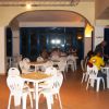 Ristorante con sedie bianche e tavoli occupati.