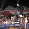 Un acrobata in equilibrio su una piattaforma di fronte a una folla di spettatori.