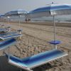 Ombrelloni e lettini blu su una spiaggia sabbiosa.