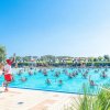 Piscina affollata con istruttore in azione.
