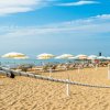 Spiaggia con ombrelloni gialli e mare.